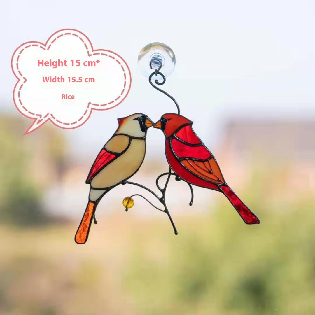 Decorative stained glass birds on a branch with a blurred natural background