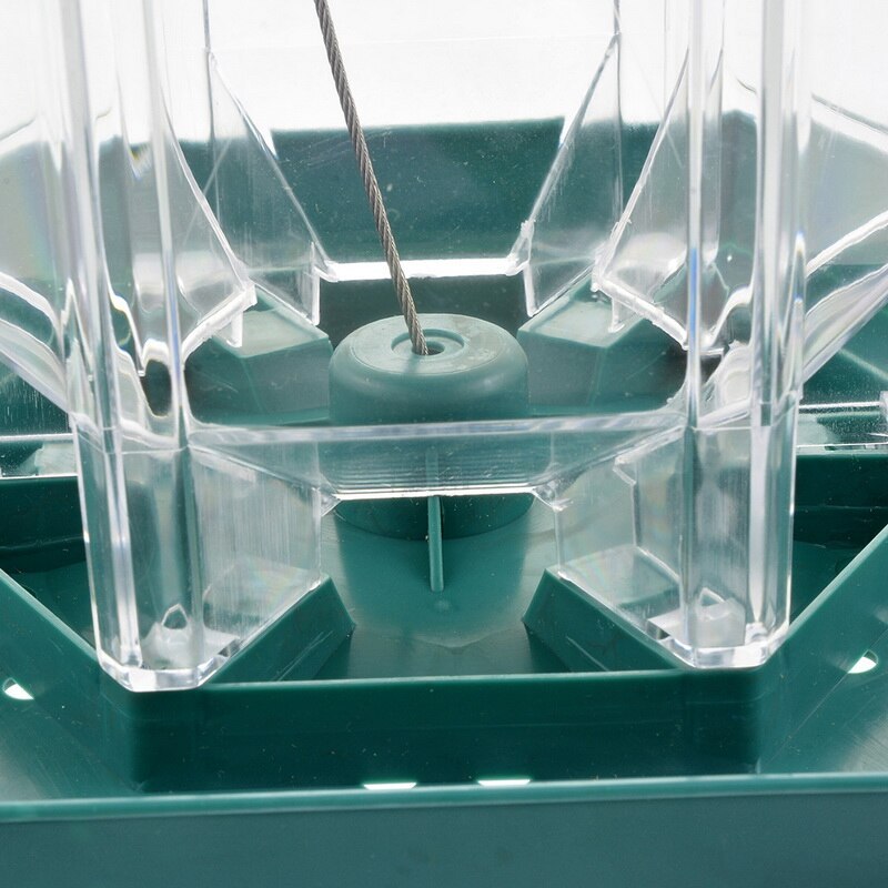 Close-up of a green mechanical device with clear plastic components.