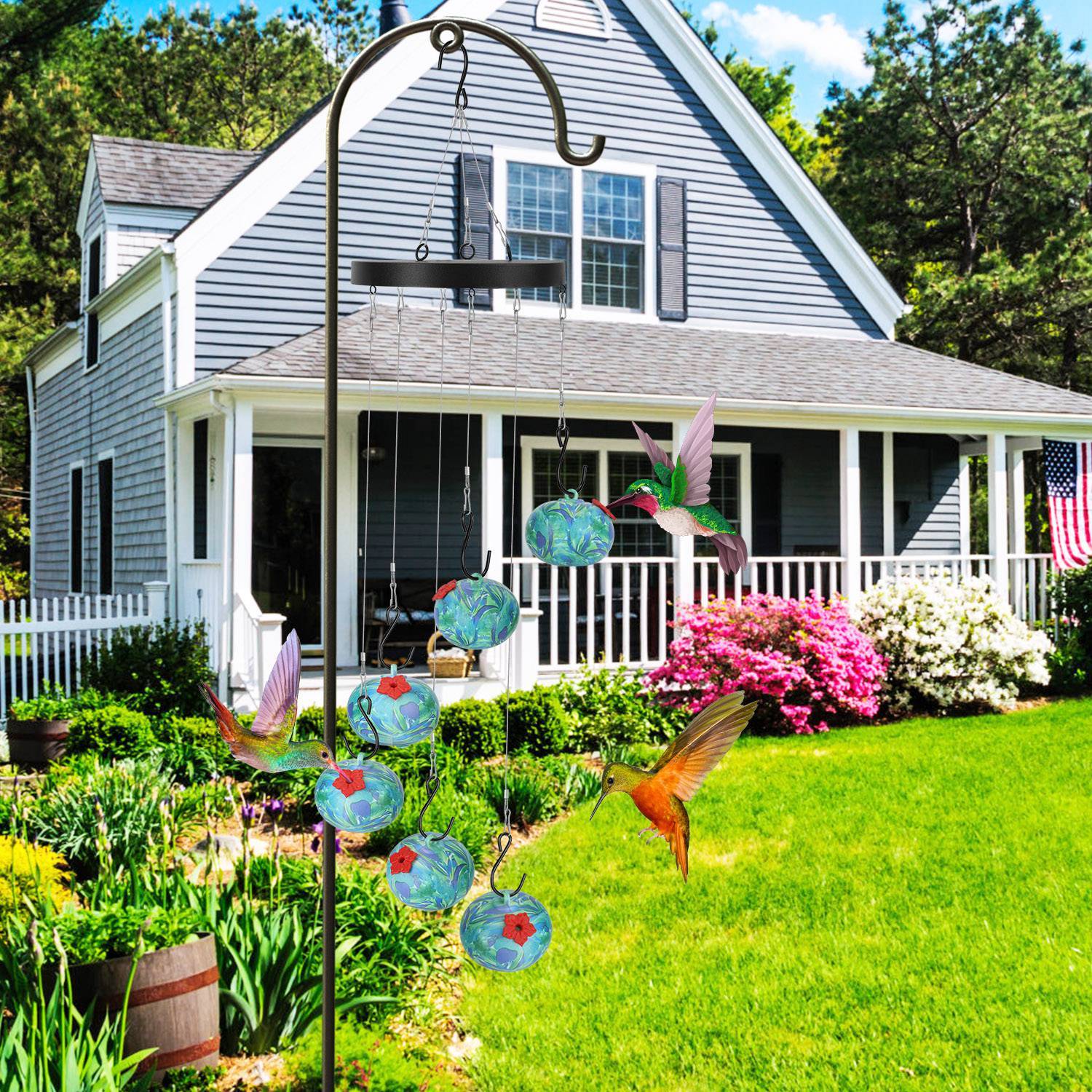 Decorative garden with hummingbird feeder in front of a house
